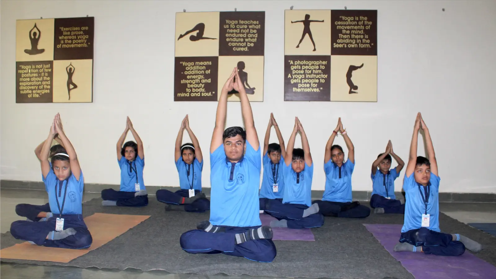 Students practising yoga together in the school hall